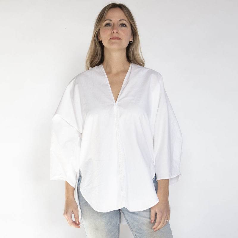 Front view of straight size model wearing White Double V Tunic Top.