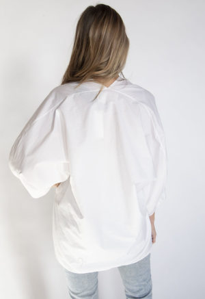 Back view of straight size model wearing White Double V Tunic Top.
