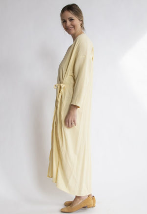 Side view of straight size model wearing Pale Yellow Gathered Wrap Dress.