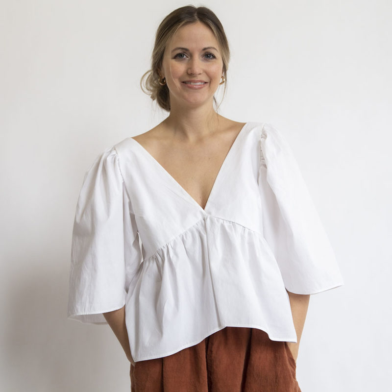 Front view of straight size model wearing White Ruffle Top.