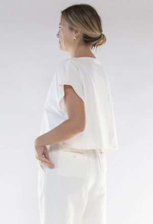 Side/back view of straight size model wearing Ivory Rib Cropped Rib Boatneck Top.