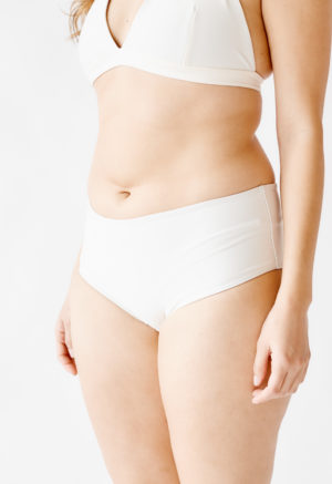 Front/side view of straight size model wearing White Hipster Bottoms.