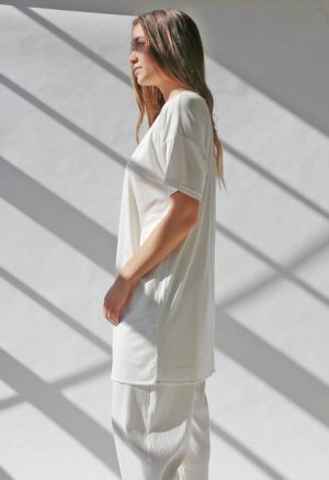 Side view of straight size model wearing White HDH Basics Tee Dress.