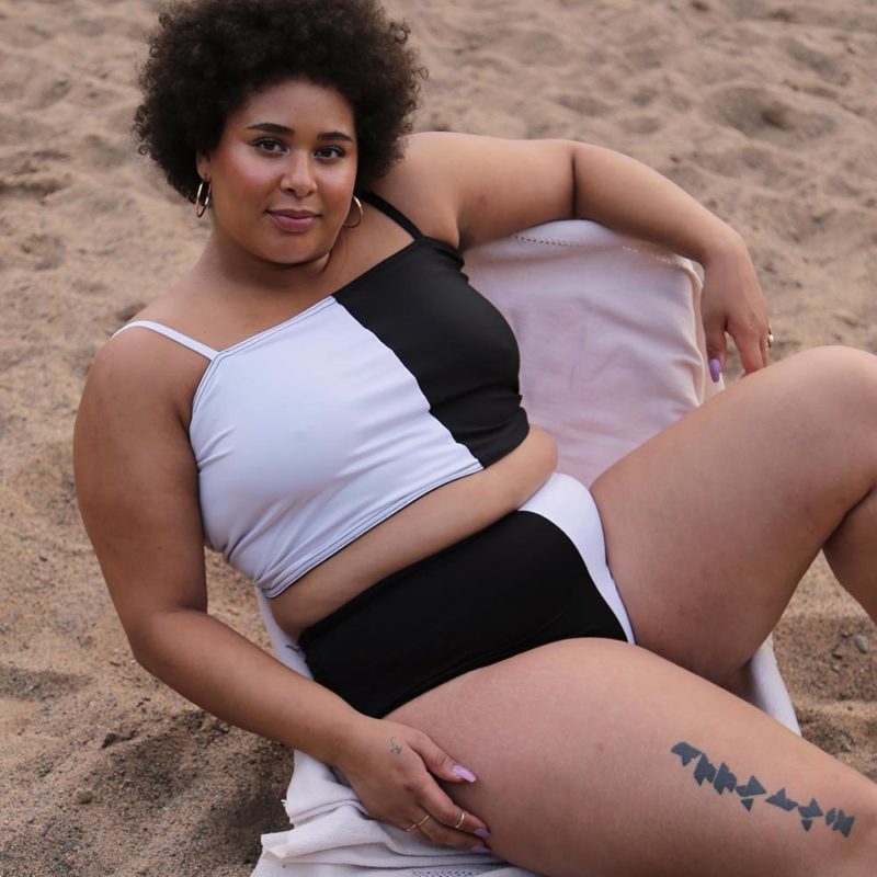 Front view of plus size model wearing Black & White Two-Tone Wrap Top.