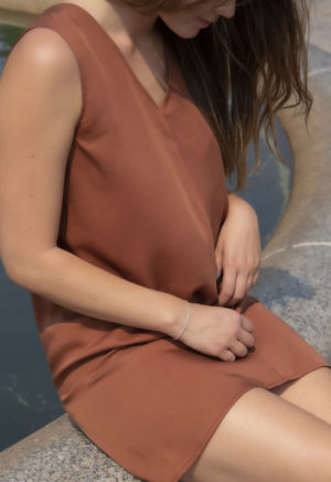 Close-up front view of straight size model wearing Copper Lyocell Shift Dress.