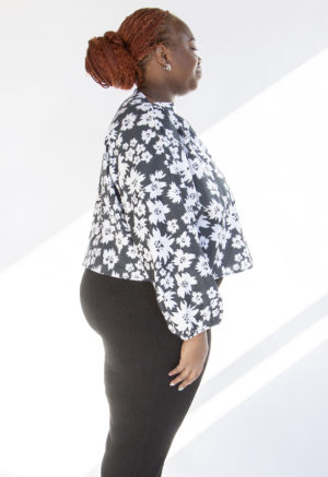 Side view of plus size model wearing Jungle Green Floral Cropped Boatneck Long-Sleeve Top.