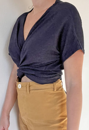 Front/side view of straight size model wearing Navy Short-Sleeve Everything Top.
