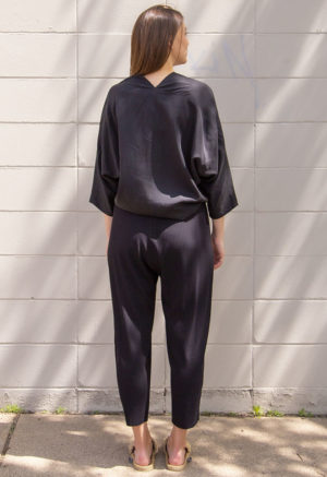 Back view of straight size model wearing Black Lyocell Bow Top.