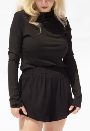 Front view of straight size model wearing Black Rib Cropped Long Sleeve Top.