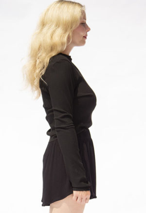 Side view of straight size model wearing Black Rib Cropped Long Sleeve Top.