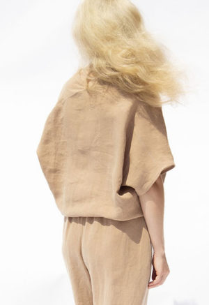 Back view of straight size model wearing Latte Linen Double V Top.