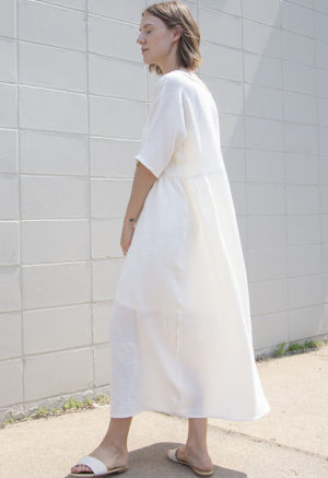 Side/back view of straight size model wearing Cream Gauze Gathered Midi Dress.