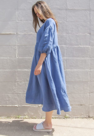 Side view of straight size model wearing Denim Linen Reversible Wrap Dress.