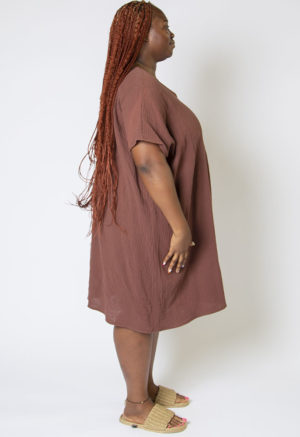 Side view of plus size model wearing Raisin Cotton Reversible Smock Dress.