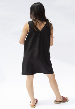 BAck view of straight size model wearing Black Lyocell Shift Dress.