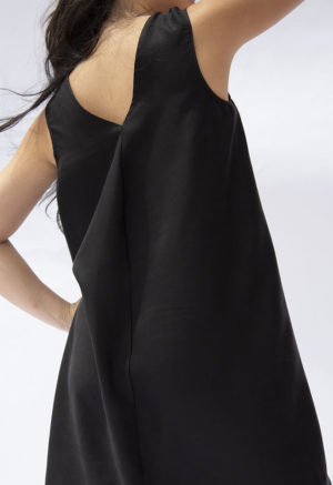 Back view of straight size model wearing Black Lyocell Shift Dress.