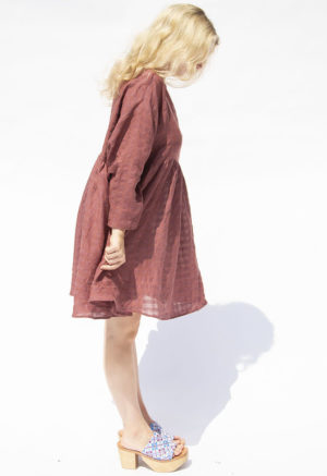 Side view of straight size model wearing Blush Check Short Oversized Dress.
