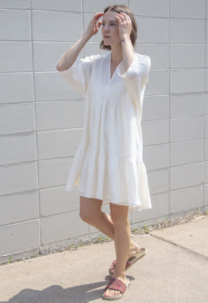 Front/side view of straight size model wearing Cream Gauze Short Tiered Dress.