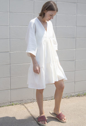 Front/side view of straight size model wearing Cream Gauze Short Tiered Dress.