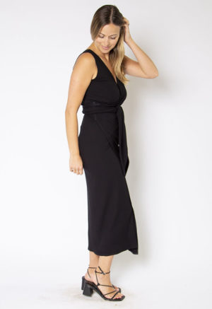 Side view of straight size model wearing Black Rib Sleeveless Wrap Dress.