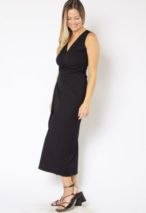 Side view of straight size model wearing Black Rib Sleeveless Wrap Dress.