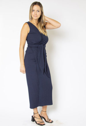 Front/side view of straight size model wearing Navy Sleeveless Wrap Dress.