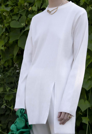 Close-up front view of straight size model wearing Ivory Tunic Slit Rib Top.