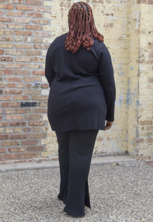Back view of plus size model wearing Black Tunic Slit Rib Top.