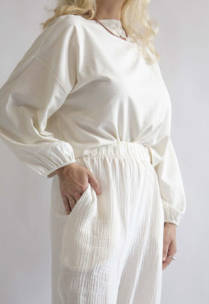 Front/side view of straight size model wearing Cream Silk Boatneck Cropped Balloon Sleeve Top.