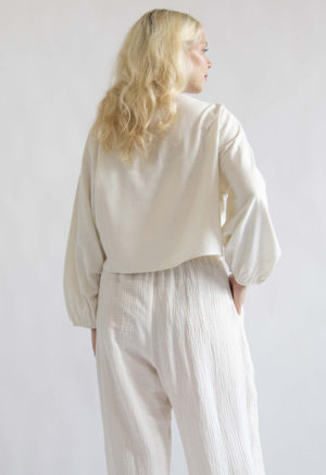 Back view of straight size model wearing Cream Silk Boatneck Cropped Balloon Sleeve Top.
