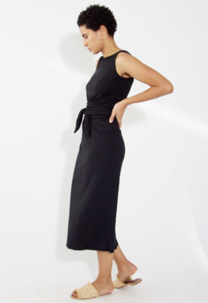 Side view of straight size model wearing Black Basics Sleeveless Wrap Dress.