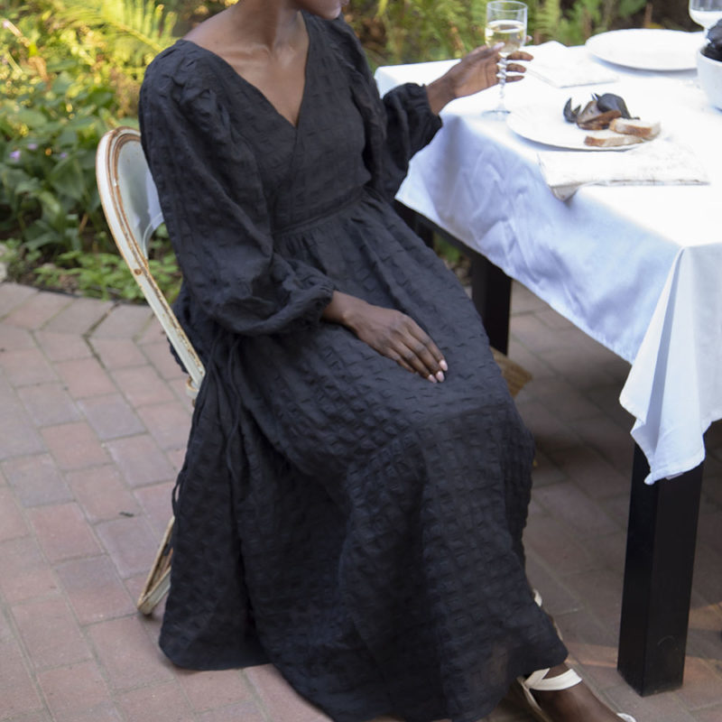 Front view of straight size model wearing Black Check Reversible Wrap Dress.