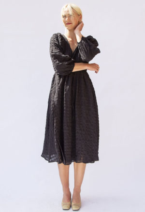 Front view of straight size model wearing Black Check Reversible Wrap Dress.
