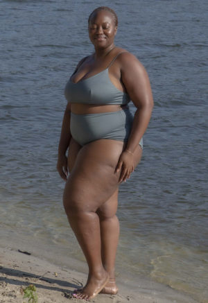 Front/side view of plus size model wearing Storm Spaghetti Strap V-Neck Top.