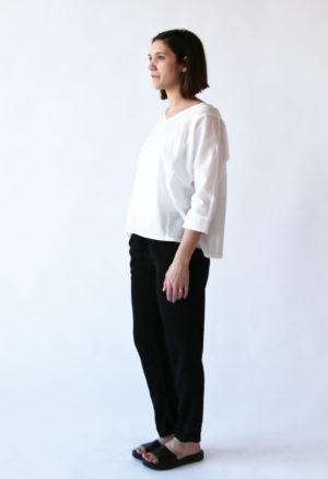 Front/side view of straight size model wearing White Calla Top.