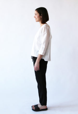 Side view of straight size model wearing White Calla Top.