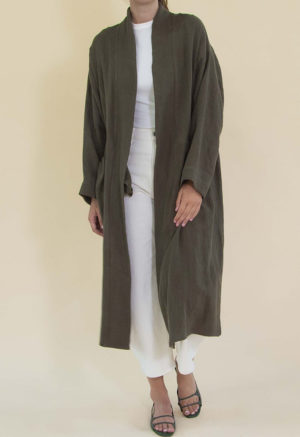 Women in dark green linen midi jacket worn over a white rib top and white jeans