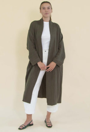 Women in dark green linen midi jacket worn over a white rib top and white jeans