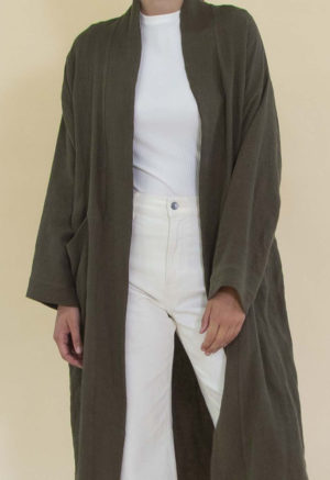 Women in dark green linen midi jacket worn over a white rib top and white jeans