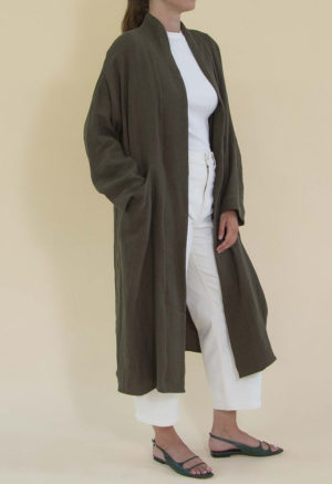 Women in dark green linen midi jacket worn over a white rib top and white jeans