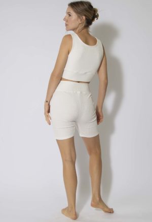 Back view of straight size model wearing Ivory Rib Reversible Scoop Bralette and Biker Shorts.