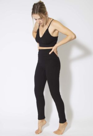 Front/side view of straight size model wearing Black Rib Leggings.