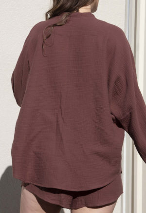 Back view of straight size model wearing Raisin Gauze Long Sleeve Dolman Button-Up Top.