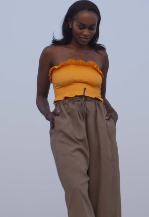 Front view of straight size model wearing Gold Ruffle Tube Top.