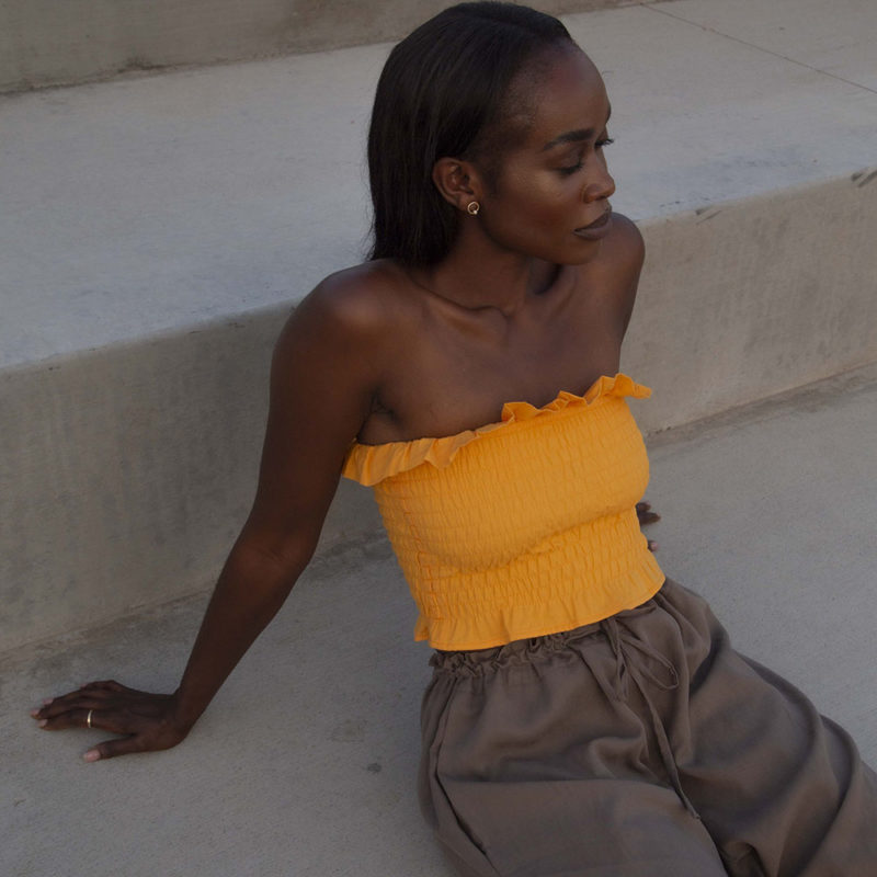 Front/side view of straight size model wearing Gold Ruffle Tube Top.