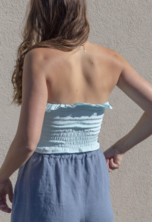 Back view of straight size model wearing Capri Blue Ruffle Tube Top.