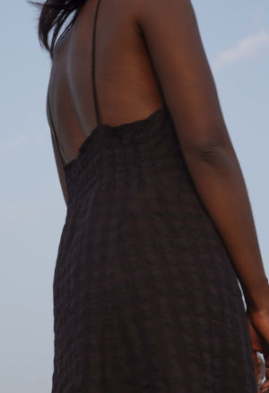 Back/side view of straight size model wearing Black Check V-Neck Maxi Slip Dress.