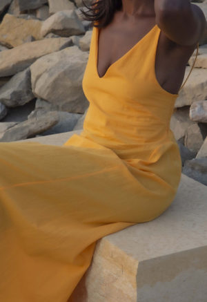 Front/side view of straight size model wearing Gold V-Neck Maxi Slip Dress.