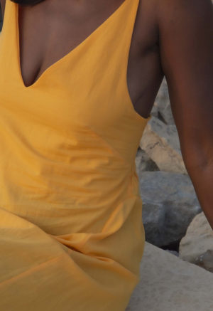 Front/side view of straight size model wearing Gold V-Neck Maxi Slip Dress.
