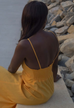 Back/side view of straight size model wearing Gold V-Neck Maxi Slip Dress.